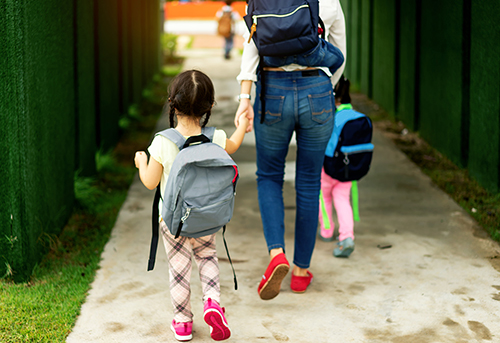 Mom and children walked hand in hand to go to school in the morning.back to school